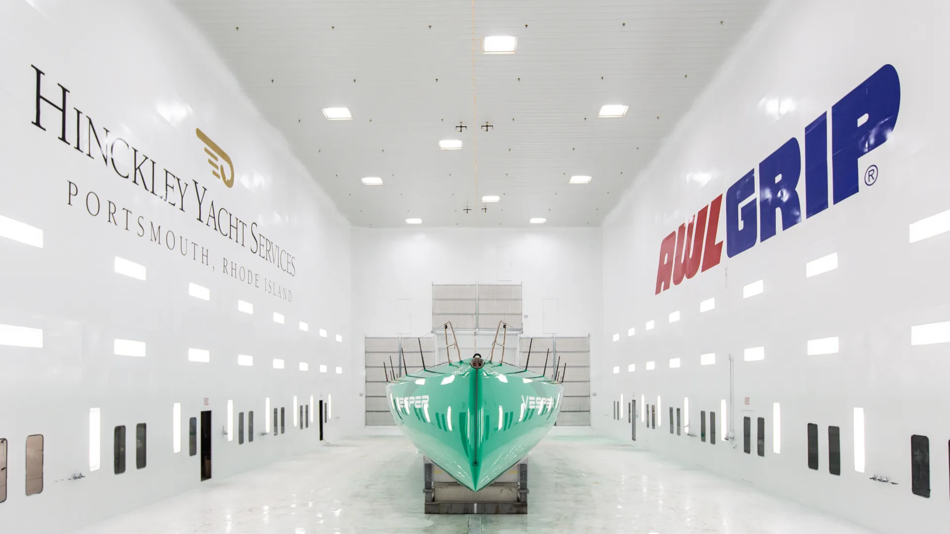 Yacht inside the Portsmouth paint booth with Hinckley and Awlgrip branding