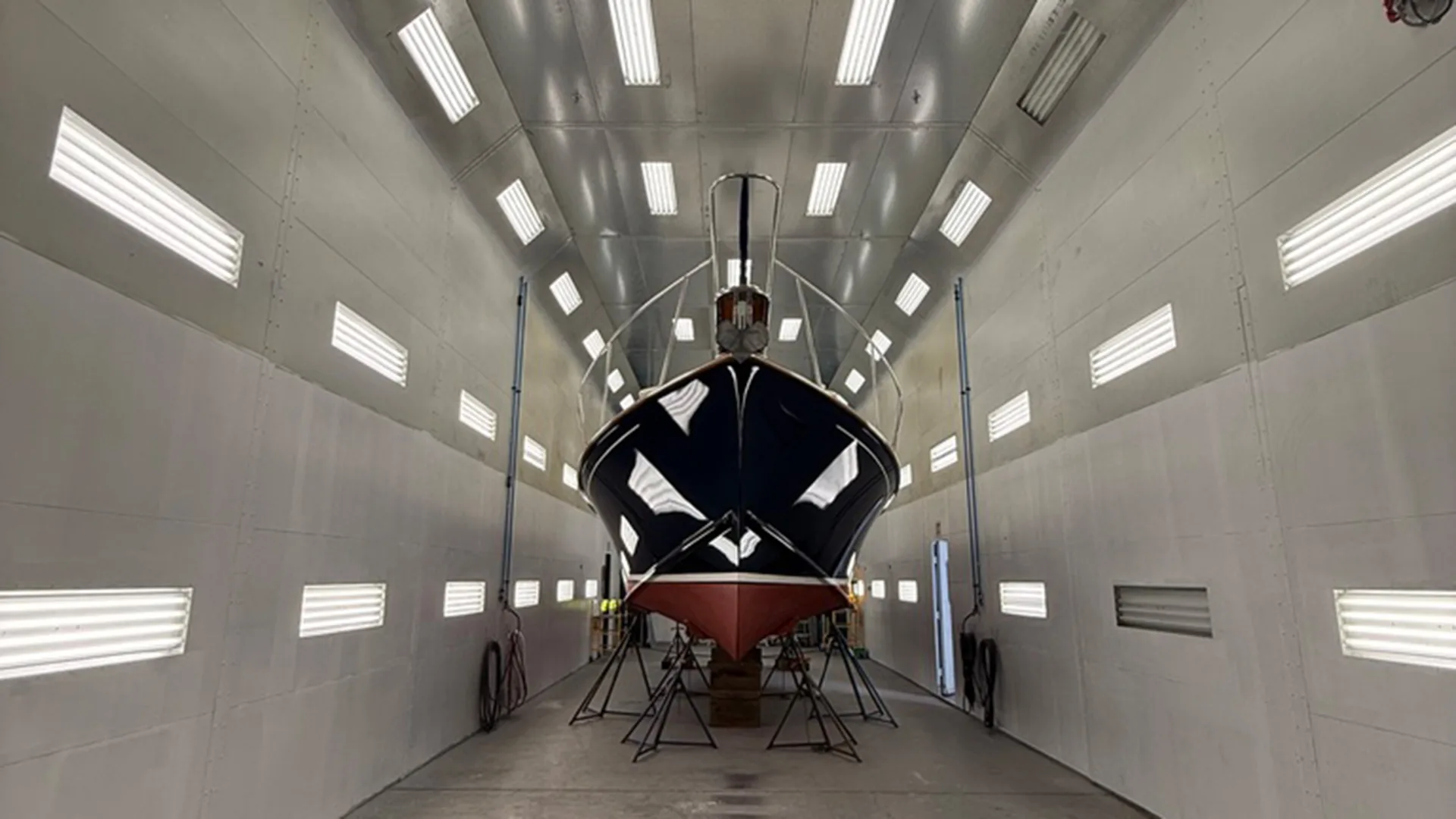 White yacht centered inside the Stamford paint booth