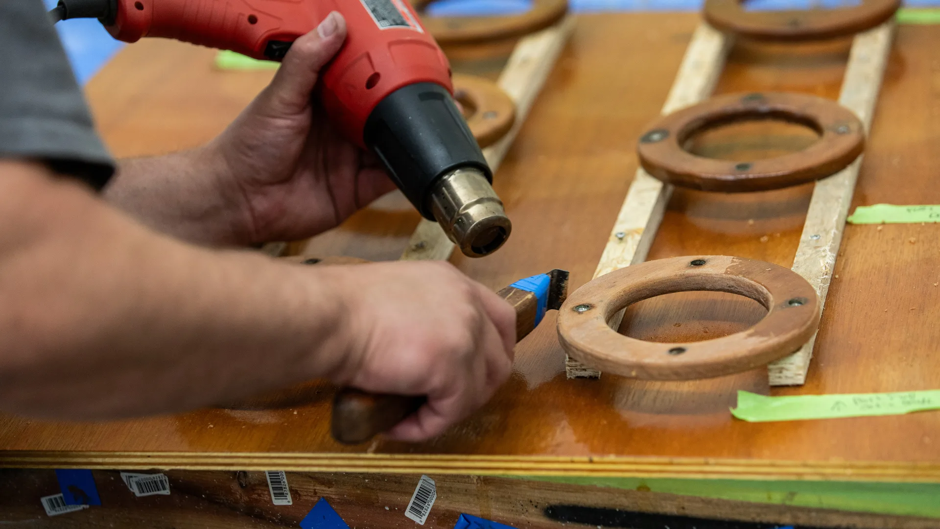 Technician heat-forming a curved piece of varnished trim in Southwest Harbor