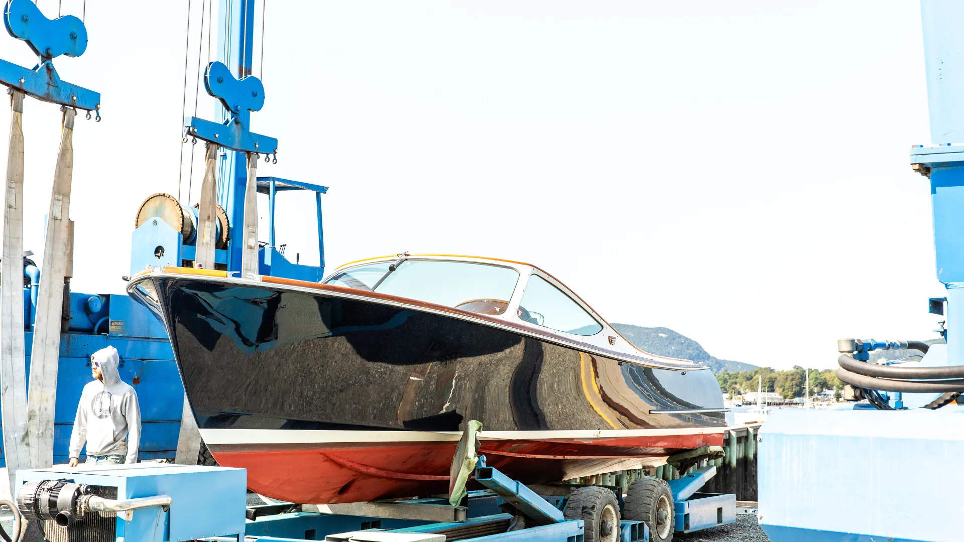 Powerboat suspended in the Southwest Harbor travelift slings