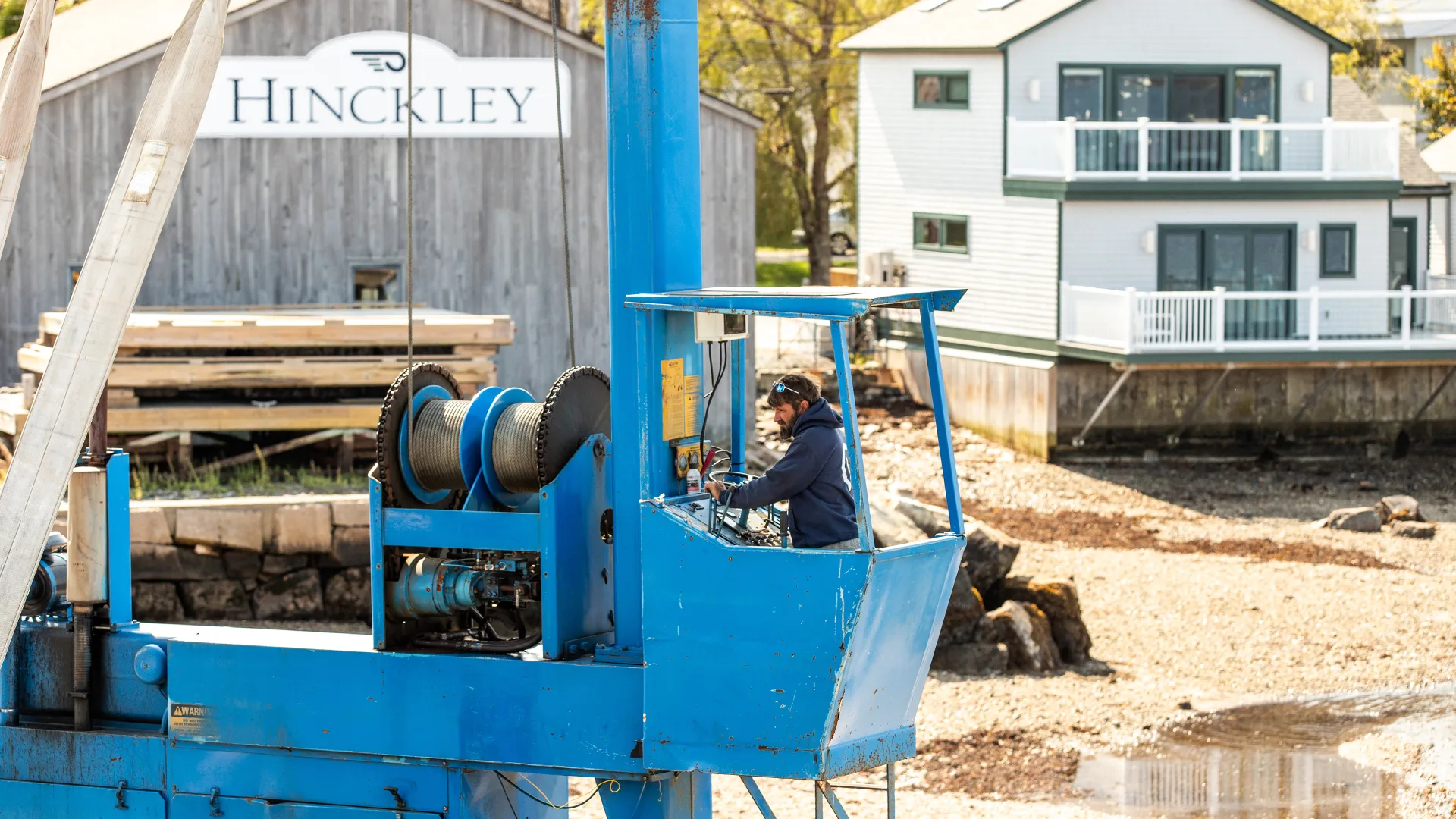 Blue marine lift parked outside the Southwest Harbor Hinckley building
