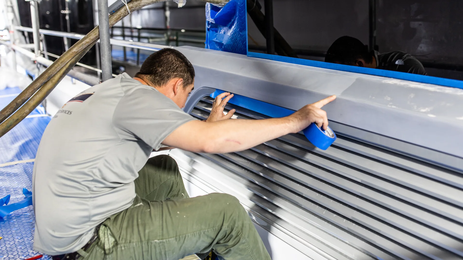 Technician detailing lettering on a yacht transom in Stuart