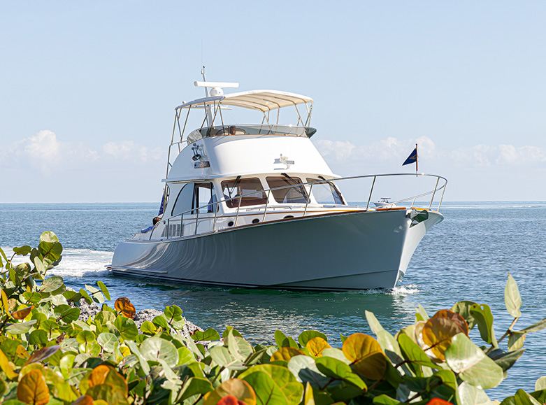 Hinckley Talaria yacht cruising along the coastline on calm ocean water