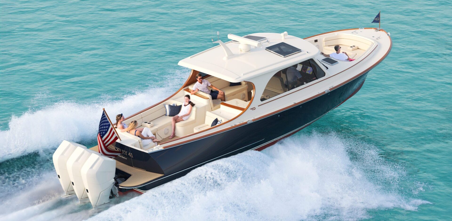 Hinckley 41 luxury motor yacht cruising on turquoise water with outboard engines