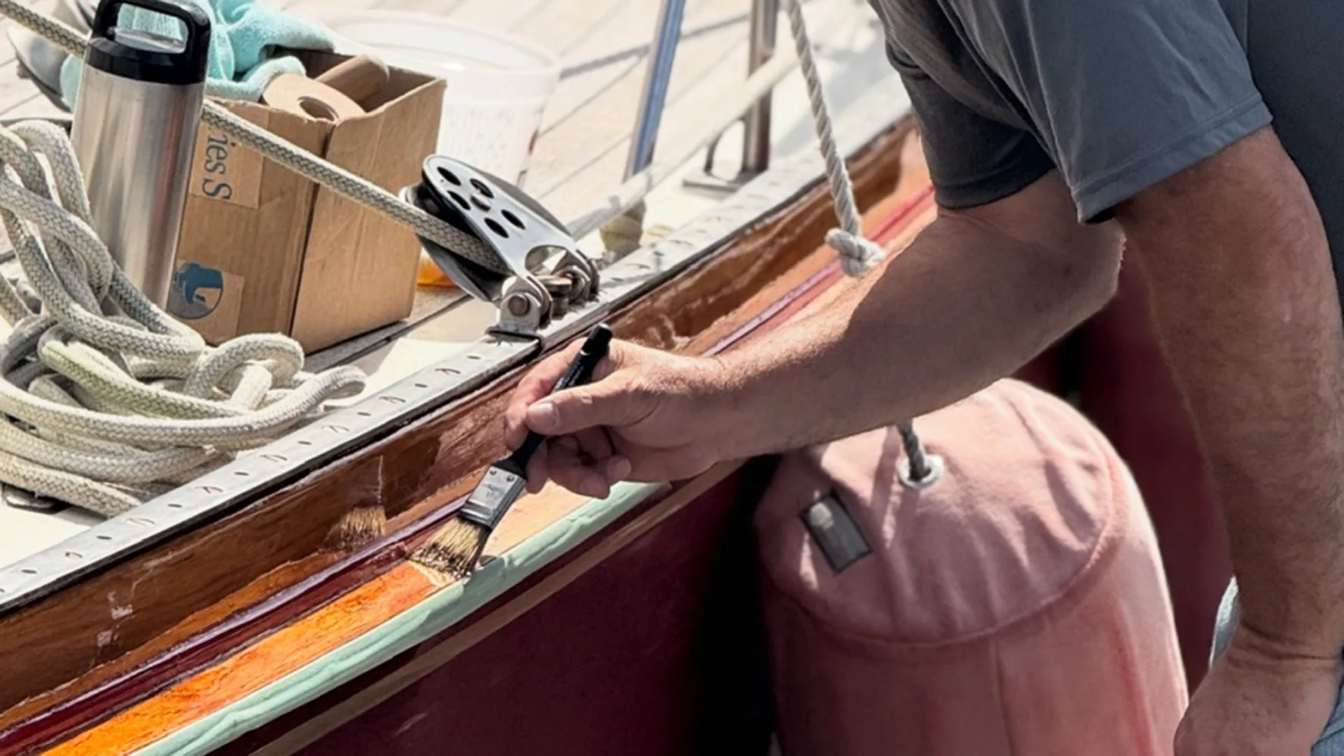 Technician refinishing varnished trim on a yacht in Oxford