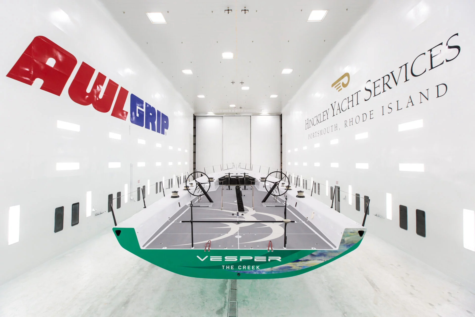 Interior of Hinckley Yacht Services’ climate-controlled paint facility in Portsmouth, Rhode Island, showing a racing yacht positioned for precision finishing.