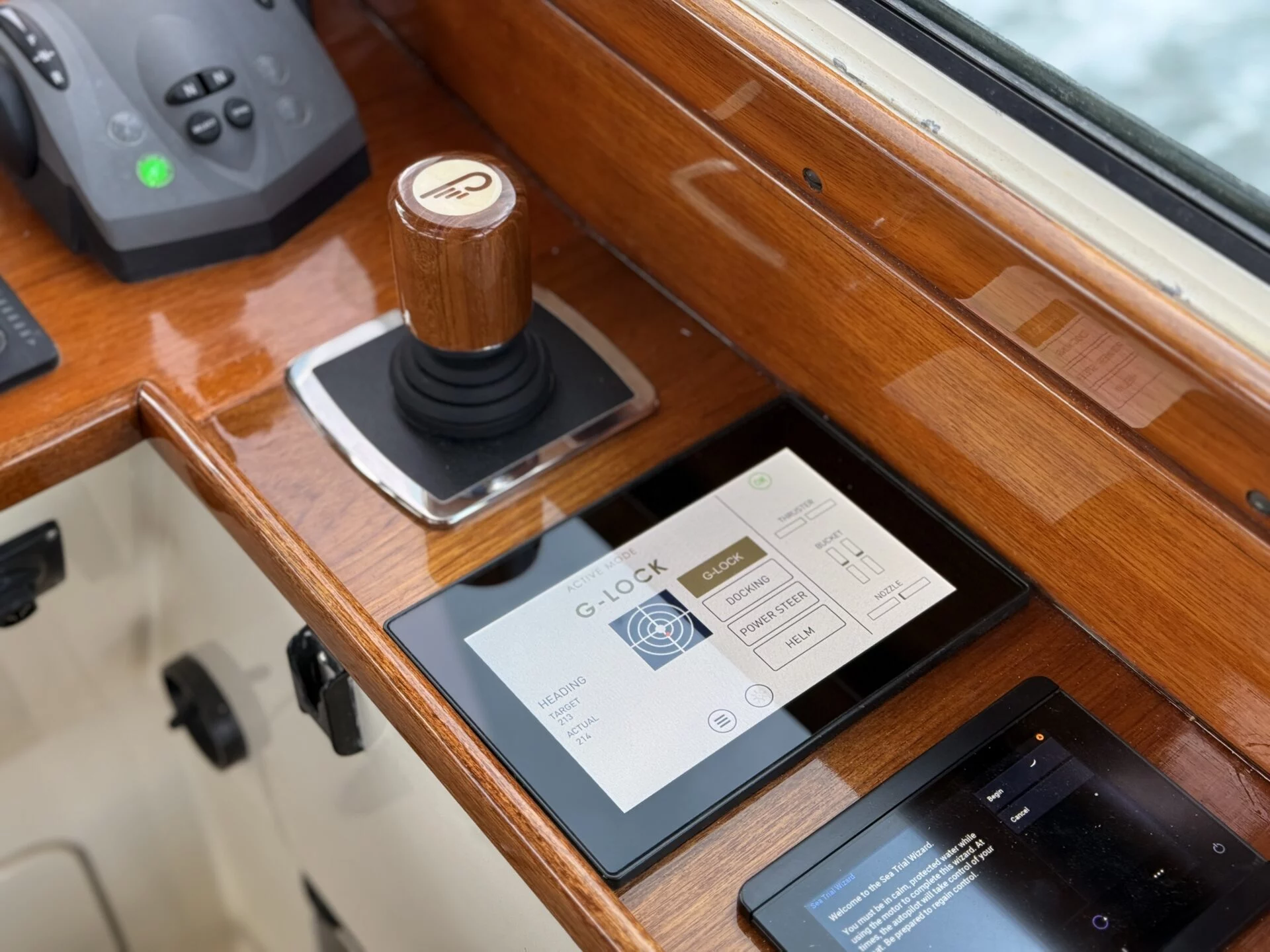 Close-up of the Hinckley Picnic Boat helm featuring a varnished wood control lever and integrated JetStick 3 joystick system.