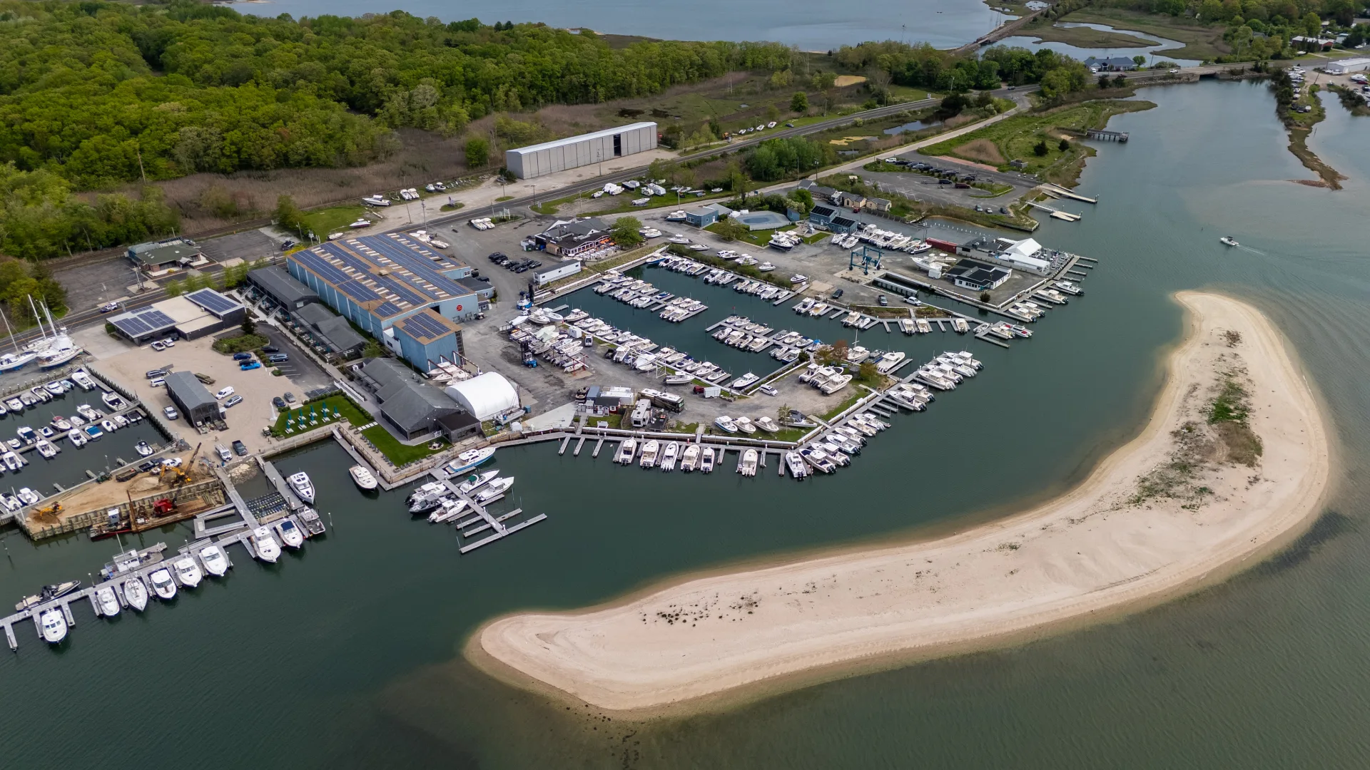 Aerial view of Port of Egypt marina slips, boats, and beach in Southold