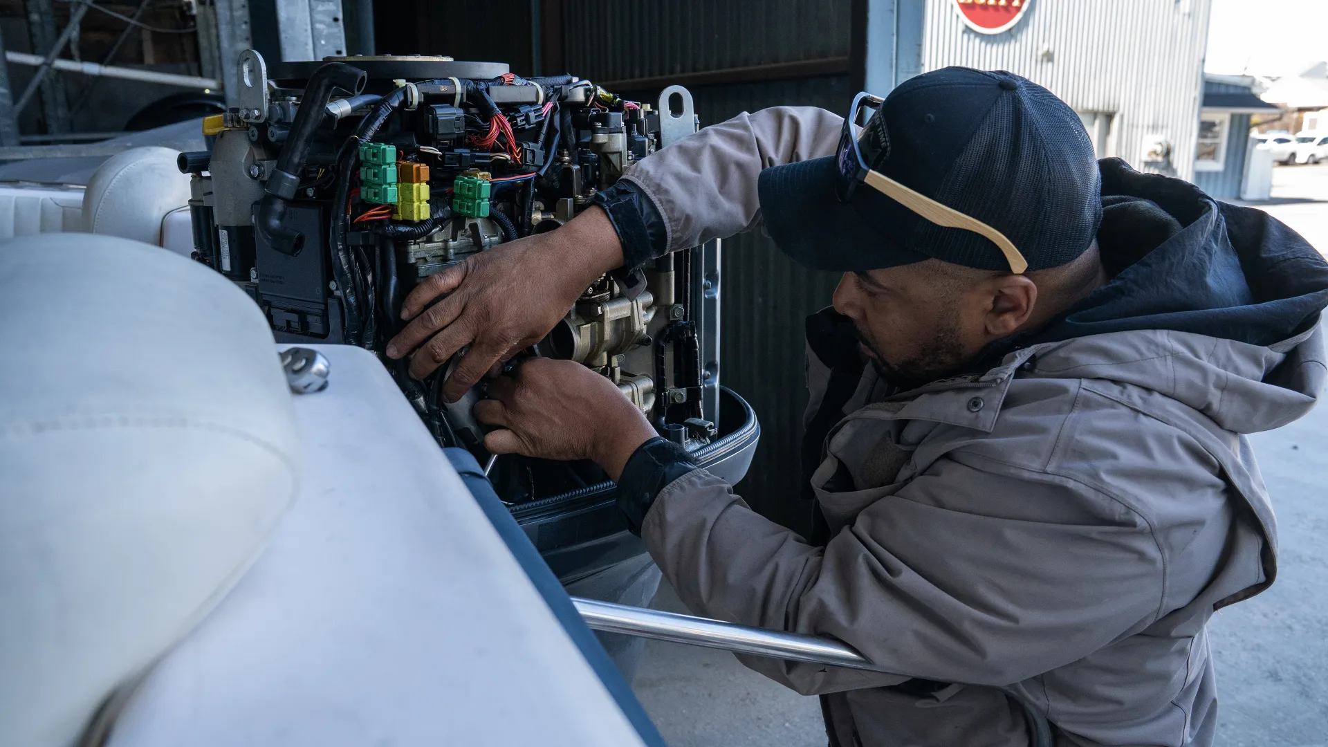 Technician working inside an open outboard engine in Southold
