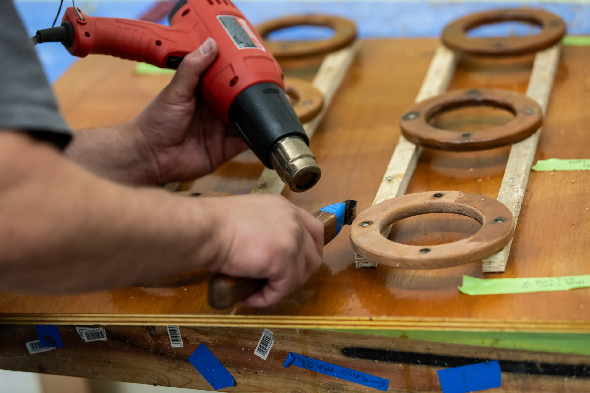 Technician heat-forming a curved piece of varnished trim in Northeast Harbor