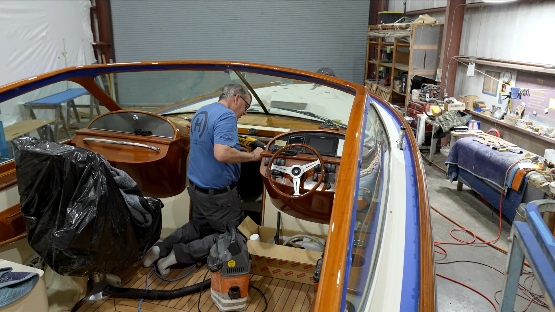 Technician working on varnished cockpit brightwork aboard a boat in Savannah