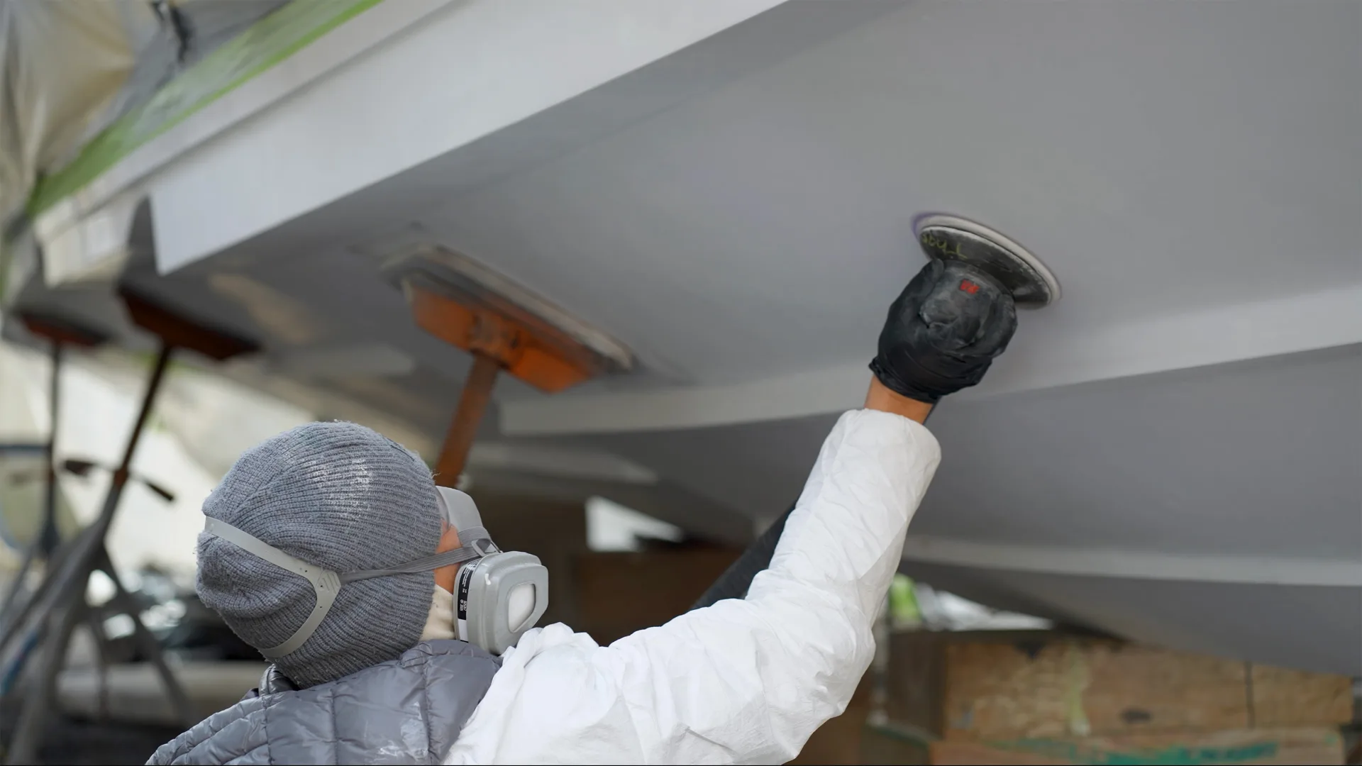Technician painting the underside of a raised hull in Savannah